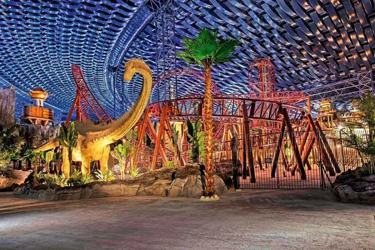 Dinosaur displays and roller coaster tracks inside IMG Worlds of Adventure