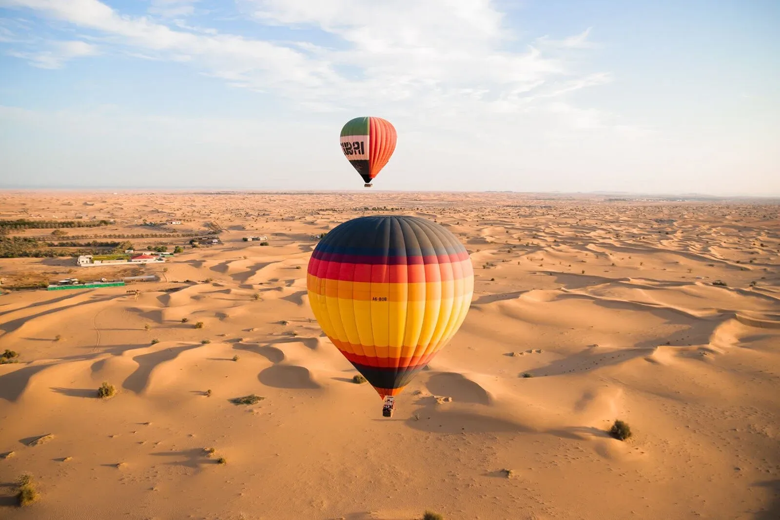 Hot air balloons floating above the Dubai desert dunes